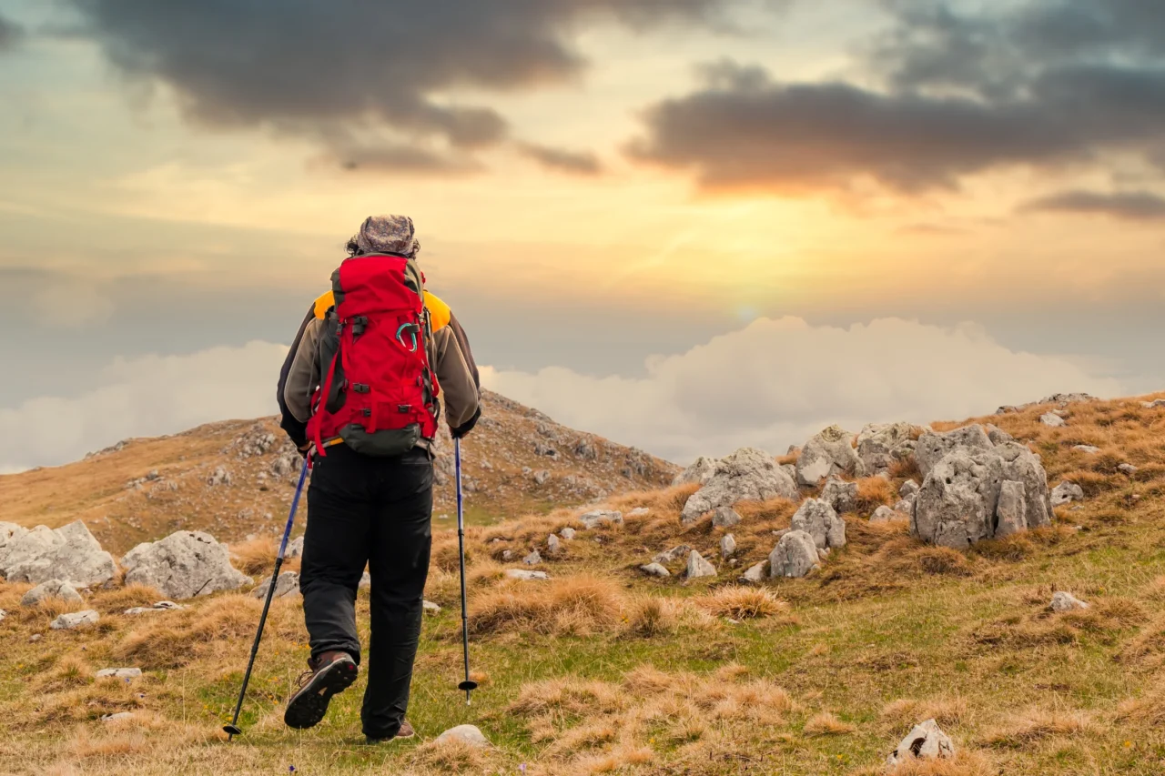 back view hiker watching sunset from mountain back view hiker watching sunset from mountain